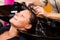 Hairdressers hand washing female customer\'s hair