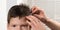 The hairdressers hands are combing the boy`s wet hair before cutting, close-ups