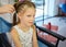 Hairdressing services. Reating hairstyle. Hair styling process. Children hairdressing salon