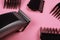 Hairdressing tool, hair clipper with nozzles on a pink background closeup