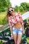 Haired beautiful girl with glasses, smiling outdoor young happy, shirt, a bright sun in denim shorts,