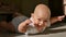 Hairless toddler lying on the floor and looking at the camera with toothyless smile