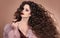 Hairstyle. Fashion brunette girl with Long curly hair, beauty ma