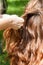 Hairstylist braiding pigtails to young girl outdoor. Creating braids.