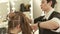 Hairstylist combing female hair during haircutting in hairdressing salon. Close up woman hairstyle in beauty salon