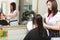 Hairstylist combing hair woman client in hairdressing beauty salon