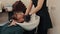 Hairstylist hand washing male hair in barber salon. Close up wash head with massage in barber shop. Male hairdresser