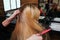 Hairstylist hands combing blonde hair before hair care procedures in beauty salon