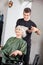 Hairstylist Straightening Female Client\'s Hair
