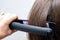 Hairstylist straightening the hair. Professional ultrasonic iron tool