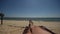 Hairy bare male legs on a beach lounger. First-person view of the beach and the sea on the horizon. A man tans. Vacation