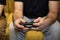 Hairy male gamer hands holding video game console gamepad close up