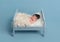 Hairy newborn sleeping on tiny bed