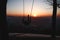 Hairy young boy aged 16-20 of European descent enjoys his life swinging on a swing at sunset on the top of Prasiva mountain in the