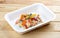 Hake fricassee with vegetables. Healthy diet. Takeaway food. On a wooden background