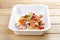 Hake fricassee with vegetables. Healthy diet. Takeaway food. On a wooden background