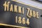Hakki Zade was established in 1864 as a confectioner. Hakki Zade sign photographed nearby. Gold color on black surface.