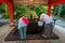 HAKONE, JAPAN - JULY 02, 2017: Unidentified people drinking water at the enter of red Tori Gate at Fushimi Inari Shrine