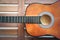 Half acoustic guitar on wooden background