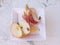 Half apple part with apple slices on a white saucer with apple peel, peeling organic red Pink Lady apple, on a table
