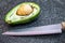 Half an avocado fruit and kitchen knife