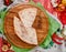 Half of the baked calzone closed type of pizza that is folded in half, on round wooden board on red wooden background