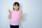 Half-body photo of an Asian girl raising her hand showing love in a pink shirt on a white background.