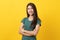 Half body shot beauty asian confidence teenager in green tee shirt folded arms and smiling stand isolated on yellow background.