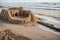 A half built sandcastle washed away by the incoming tide