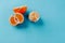 Half of clementines and one peeled on a blue background with copy space