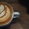 Half coffee cup with latte art on the wood table