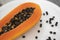 Half cut ripe papaya with seed on a white plate. Slices of sweet papaya with a white background. Halved papayas. Healthy