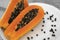 Half cut ripe papaya with seed on a white plate. Slices of sweet papaya with a white background. Halved papayas. Healthy