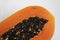 Half cut ripe papaya with seed on a white plate. Slices of sweet papaya with a white background. Halved papayas. Healthy