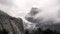 half dome covered in snow and mist during a winter storm at yosemite