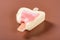 Half eaten strawberry flavor popsicle on a brown background no logo no trademark