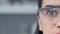 Half face of a female biologist in safety glasses with copy space. Closeup portrait of a scientist or medical expert