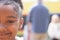 Half face portrait of smiling african american elementary schoolgirl in schoolyard, copy space