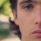 Half face of an young man. Close-up male eye - soft focus. Part of face of the young guy. Man with calm emotions on his face looks