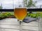 Half glass of beer on a beautiful wooden old table on the veranda of the restaurant