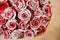 Half image of round romantic bouquet of red pion-shaped roses decorated with white powder