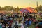 Half inflated hot air balloon in middle of huge crowd