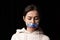 Half-legth portrait of young emotional upset girl with three colors duct tape over her mouth isolated on dark background