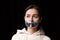 Half-legth portrait of young emotional upset girl with three colors duct tape over her mouth isolated on dark background