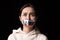 Half-legth portrait of young emotional upset girl with three colors duct tape over her mouth isolated on dark background