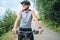 Half-length portrait of a sincerely smiling man dressed in cycling clothes, helmet and sunglasses riding a bicycle on the asphalt