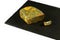 Half a loaf of mouldy rye bread and a piece of kiwi with a mold on a black shale board isolated on white background, concept of in