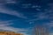 Half Moon surrounded by white cirrus clouds and blue sky