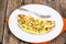 Half an omelette with vegetables on a white plate