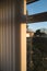 Half open vertical blinds with a golden glow as the sun sets